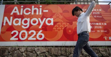 A man walks past an advertisement for the 2026 Aichi-Nagoya Asian Games, Nagoya, Aichi prefecture, Japan, Sept. 8, 2025. (AFP Photo)