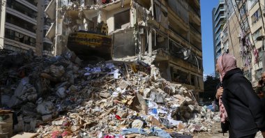A woman watches as a bulldozer clears the rubble of a destroyed building the day after an Israeli airstrike in the Ain Mreisseh neighborhood of Beirut, Lebanon, April 9, 2026. (EPA Photo)