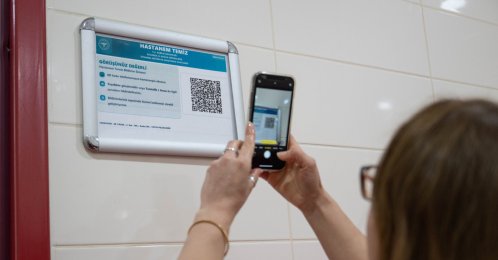 A woman scans a QR code to provide real-time feedback on hospital services, Istanbul, Türkiye, April 1, 2026. (AA Photo)