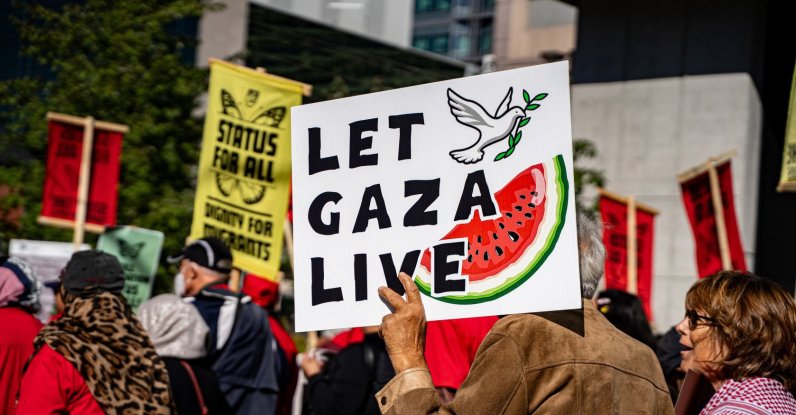 A protester holds a sign reading "Let Gaza live" and featuring a watermelon illustration, Toronto, Canada, Sept. 20, 2025. (Shutterstock Photo)