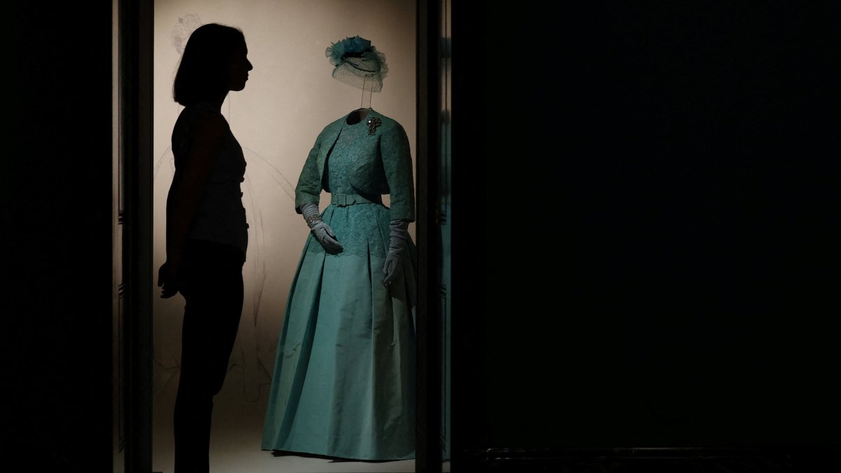 A Royal Collection Trust poses beside an item forming part of "Queen Elizabeth II: Her Life in Style" in The King’s Gallery at Buckingham Palace, London, U.K., April 9, 2026. (Reuters Photo)