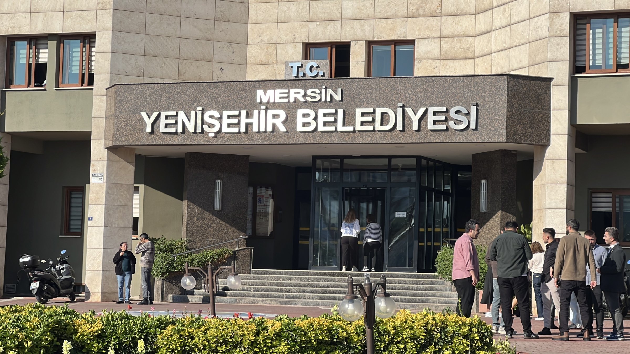 Onlookers gather outside the Yenişehir municipal building following the detention of 30 officials in an ongoing corruption probe, southern Mersin, Türkiye, April 10, 2026. (IHA Photo)
