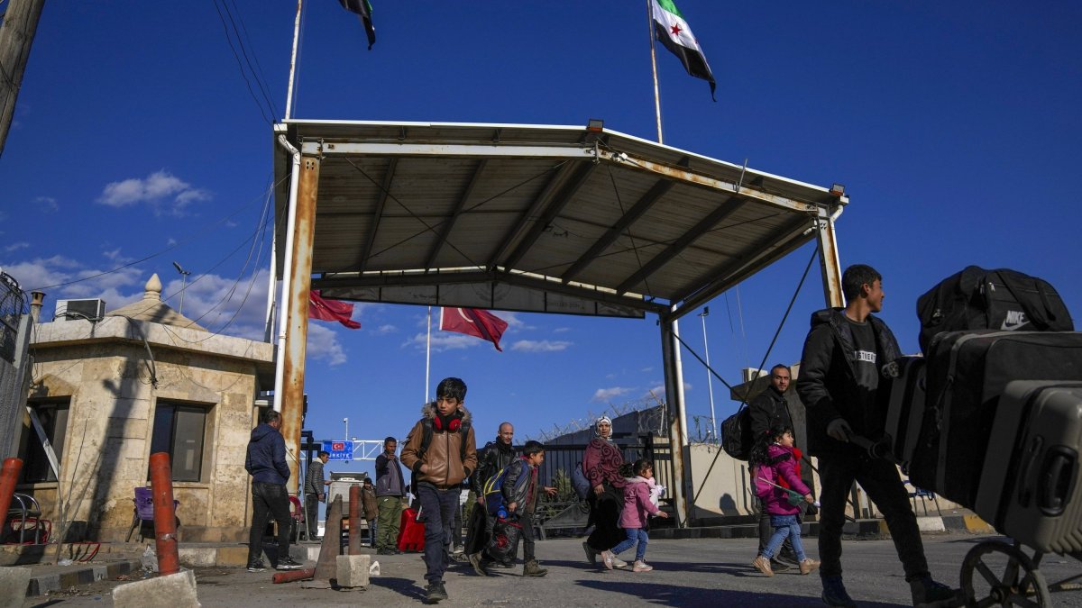 Syrians cross the border from Türkiye into Syria at the Bab al-Salama crossing gate, Syria, Dec. 13, 2024. (AP Photo)