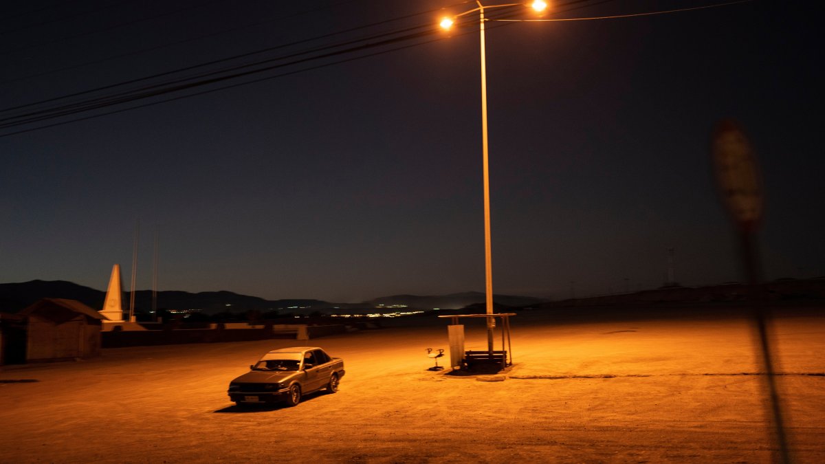 A driver sits in his car in an empty parking lot in Calama, Chile, April 14, 2023. (AP Photo)
