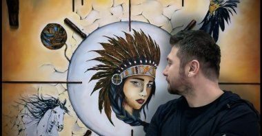 Turkish artist Vahap Aydoğan looks at one of his artworks in this undated photo. (Photo courtesy of Vahap Aydoğan)