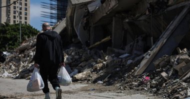 A man carries bags with food and basic supplies from an aid distribution to displaced families, Beirut, Lebanon, March 28, 2026. (Reuters Photo)