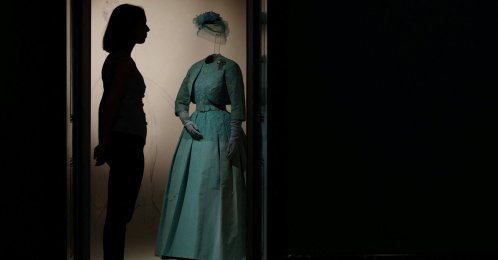 A Royal Collection Trust poses beside an item forming part of "Queen Elizabeth II: Her Life in Style" in The King’s Gallery at Buckingham Palace, London, U.K., April 9, 2026. (Reuters Photo)