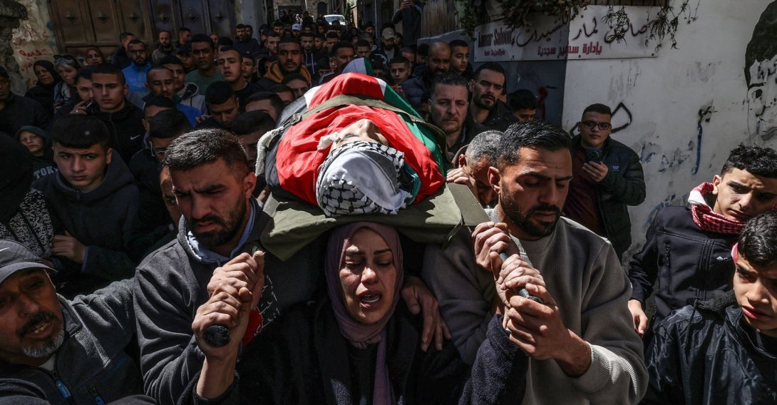 Hanan, the mother of Adam, a 15-year-old Palestinian who was killed by Israeli security forces in the al-Dheisheh refugee camp near the occupied West Bank city of Bethlehem, carries her son's body during his funeral, March 28, 2026. (AFP File Photo)