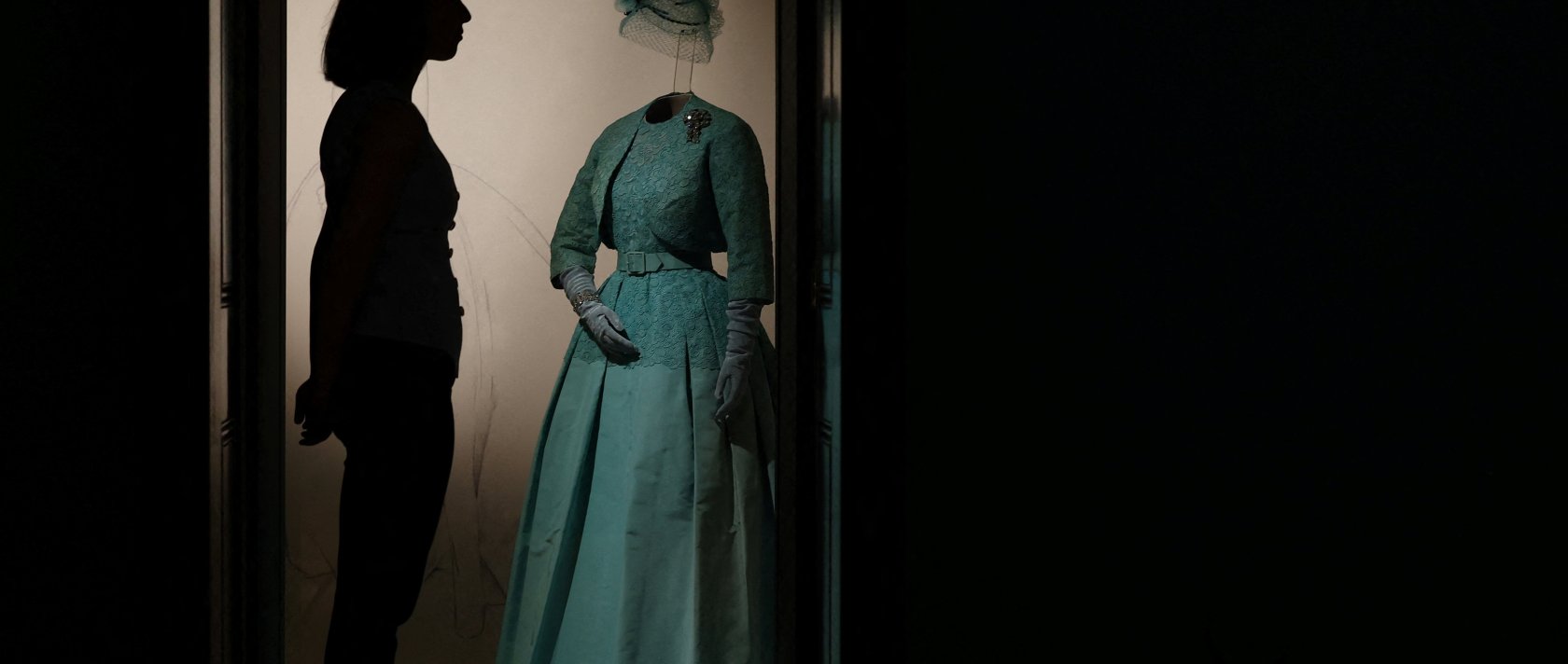 A Royal Collection Trust poses beside an item forming part of "Queen Elizabeth II: Her Life in Style" in The King’s Gallery at Buckingham Palace, London, U.K., April 9, 2026. (Reuters Photo)