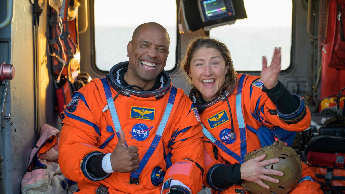 NASA astronauts Victor Glover (L) and Christina Koch sit on a Navy MH-60 Seahawk helicopter on the flight deck of USS John P. Murtha after they and fellow crewmates were extracted from their Orion spacecraft after splashdown, in the Pacific Ocean off the coast of California, U.S., April 10, 2026. (AFP Photo)