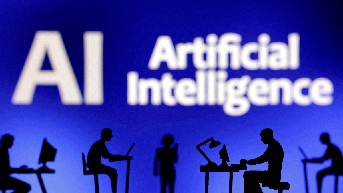 Figurines with computers and smartphones are seen in front of the words "Artificial Intelligence, AI" in this illustration created on Feb. 19, 2024. (Reuters Photo)