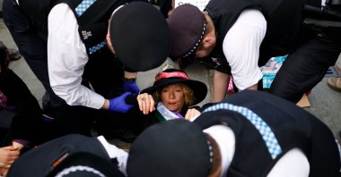 Police officers arrest a supporter of Palestine Action dressed as a suffragette during a mass protest organized by the Defend Our Juries group at Trafalgar Square in London, U.K., April 11, 2026. (EPA Photo)