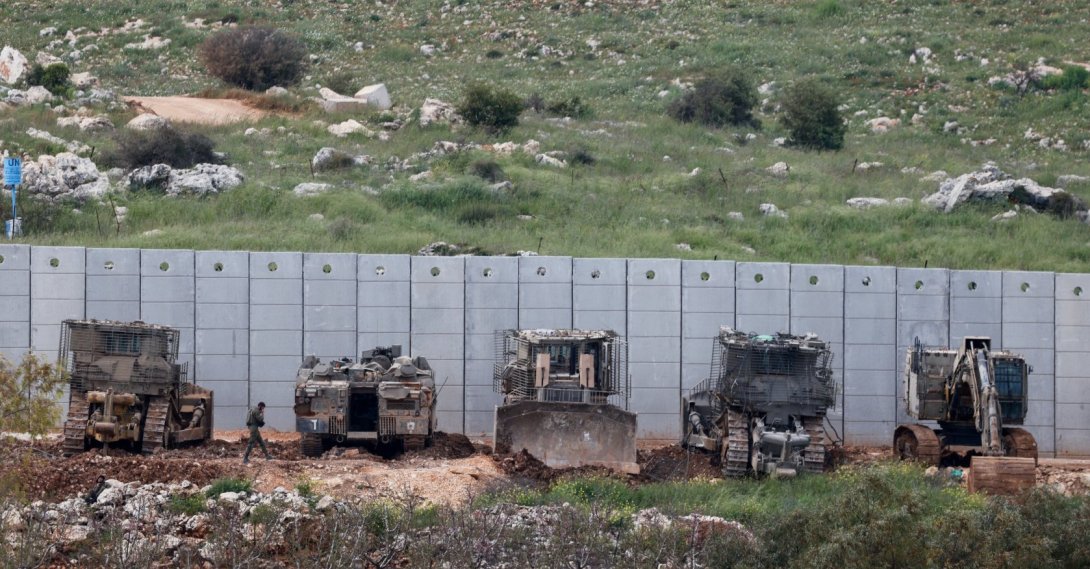 An Israeli soldier walks near armored military engineering vehicles on the Israeli side of the border, April 12, 2026. (Reuters Photo)