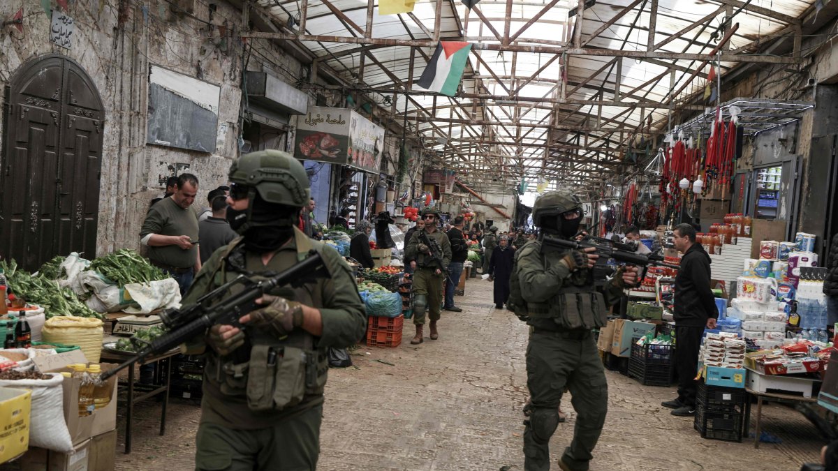 Israeli soldiers patrol through the market in the Old City of Nablus, Israeli-occupied West Bank, Palestine, April 12, 2026. (AFP Photo)