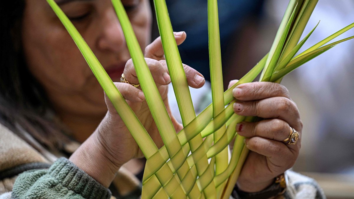 A Christian worshipper arranges a palm frond during mass at the Cave Church at the Coptic Orthodox Monastery of Simon the Tanner in the eastern hillside on Orthodox Palm Sunday, Mokkatam district, Cairo, Egypt, April 5, 2026. (AFP Photo)