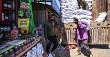 Workers unload goods from the back of a truck at the Jamila food market in Sadr City, east Baghdad, Iraq, April 13, 2026. (AFP Photo)