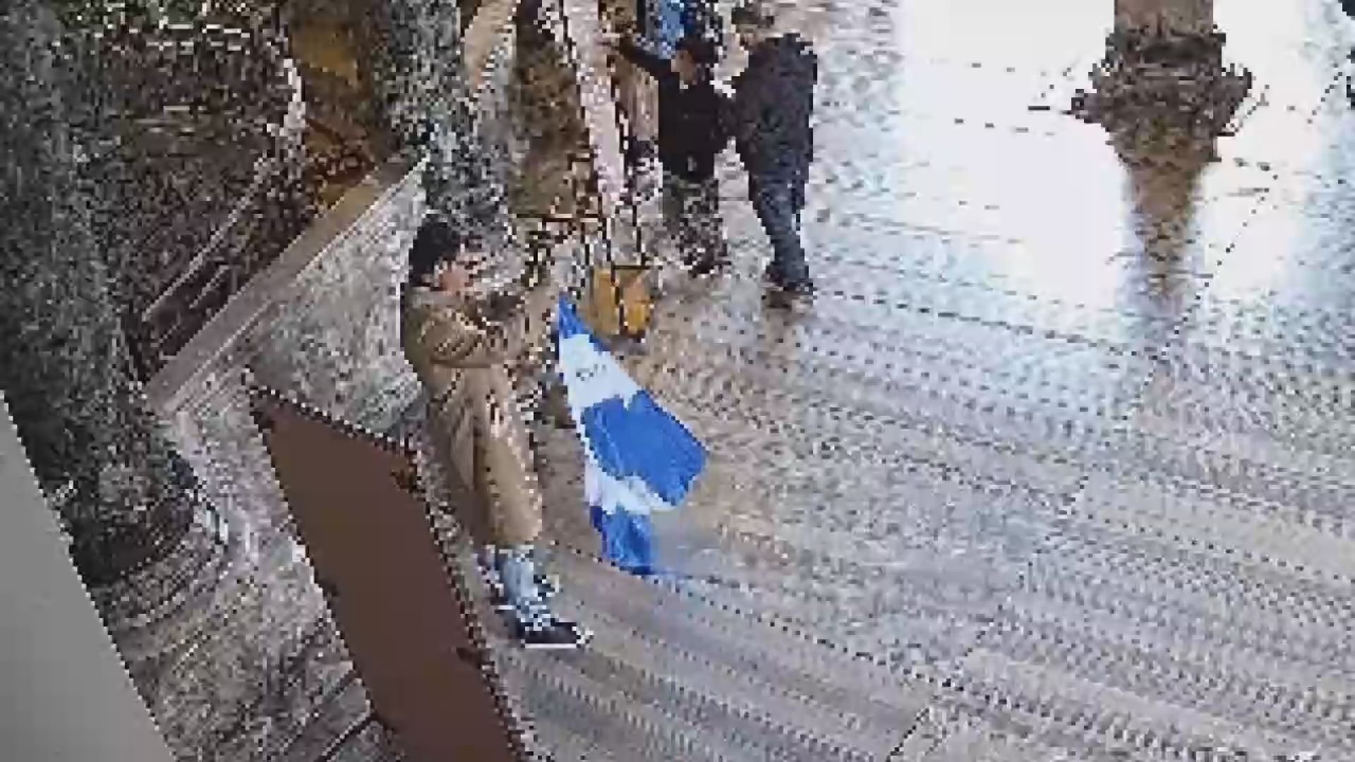 One of the two suspects is seen unfurling a 