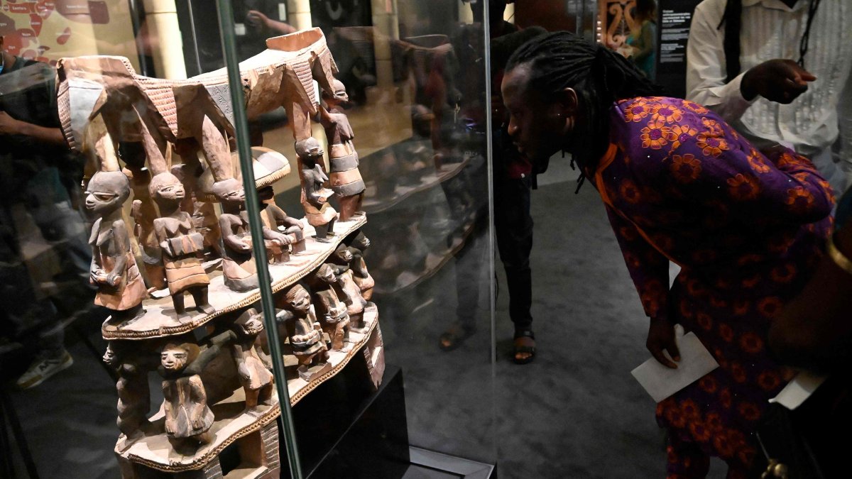 A man looks at a throne from Cana, a town once looted by French colonial soldiers, during an exhibition of returned seized Benin artifacts, Cotonou, Benin, Feb. 18, 2022. (AFP Photo)