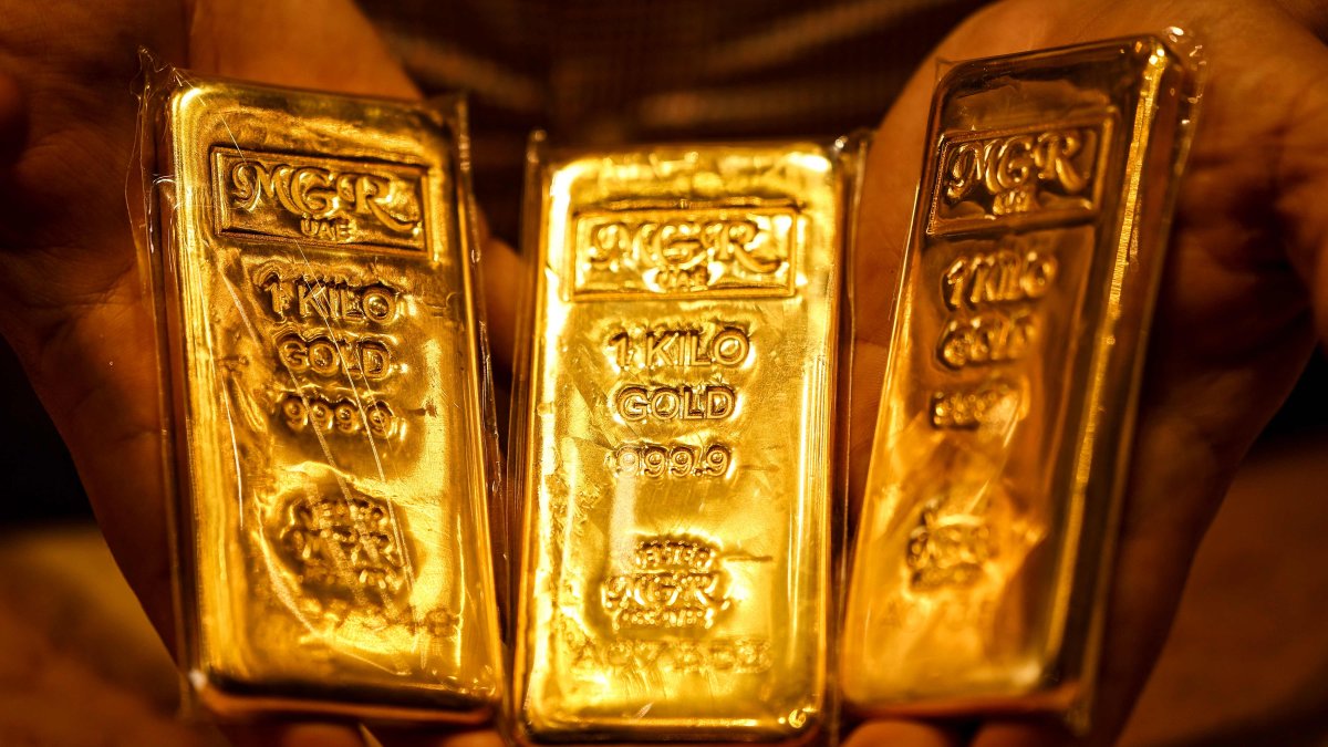 An Emirati gold dealer holds bars of gold in a shop in the Dubai Gold Souk, April 13, 2025. (AFP Photo)