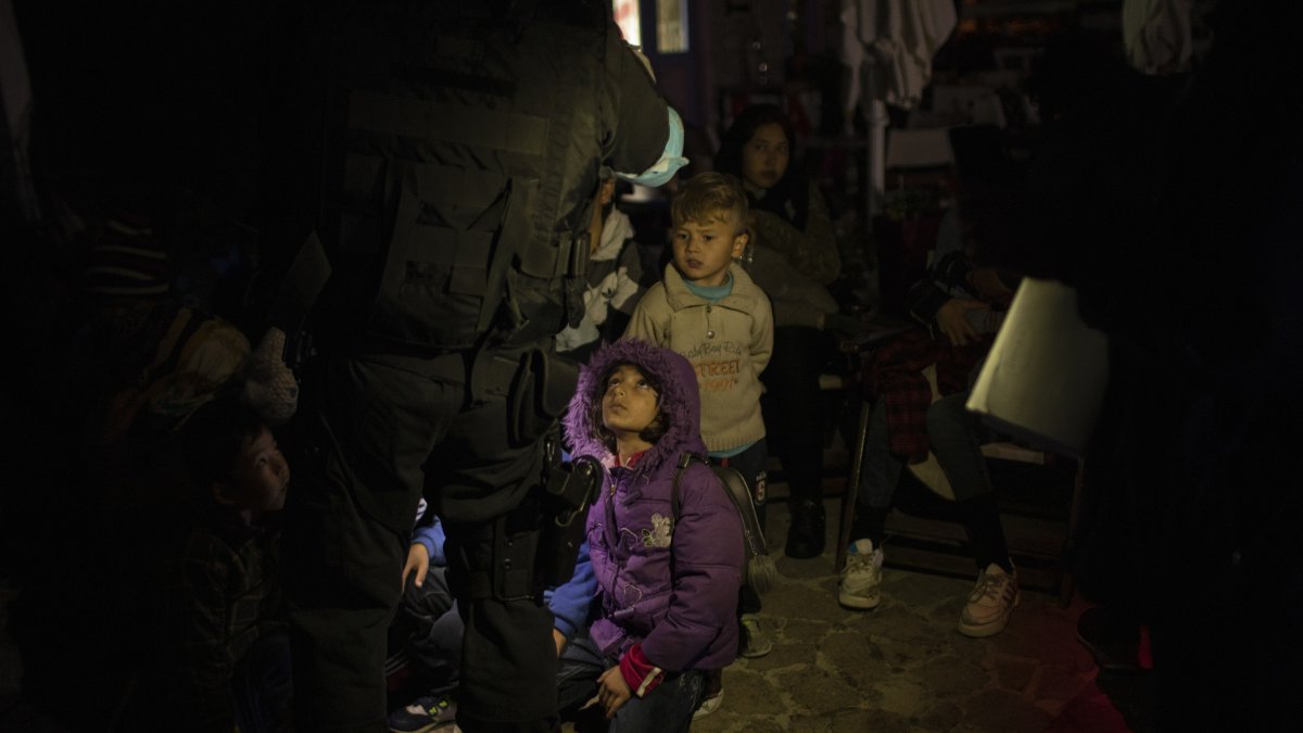 A Frontex coast guard counts migrants and refugees in the tiny harbor of Skala Sikamias, on the island of Lesbos, Greece, Oct. 3, 2019. (AP Photo)