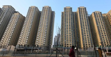 A woman walks past an Evergrande Group residential complex called Evergrande Palace, Beijing, China, Jan. 29, 2024. (AFP Photo)