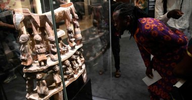 A man looks at a throne from Cana, a town once looted by French colonial soldiers, during an exhibition of returned seized Benin artifacts, Cotonou, Benin, Feb. 18, 2022. (AFP Photo)