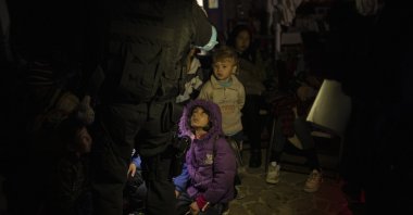 A Frontex coast guard counts migrants and refugees in the tiny harbor of Skala Sikamias, on the island of Lesbos, Greece, Oct. 3, 2019. (AP Photo)