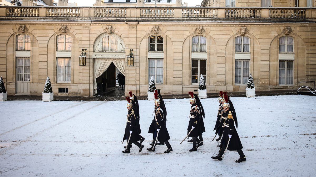 Republican Guards walk in the snow-covered courtyard of the Elysee Palace in Paris, France, Jan. 6, 2026. (AP Photo)