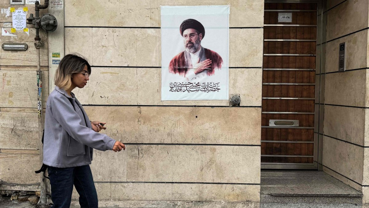 An Iranian woman walks past a poster featuring a portrait of Iran’s new Supreme Leader Mojtaba Khamenei, Tehran, Iran, April 13, 2026. (AFP Photo)