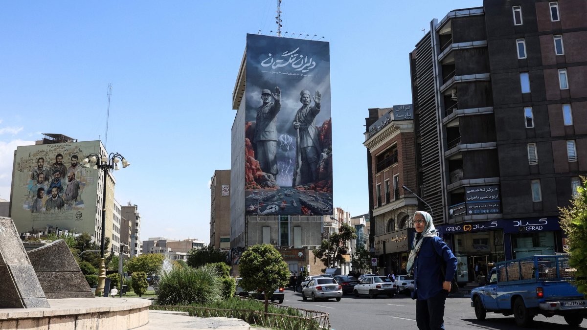 A woman walks past a large billboard referring to the Strait of Hormuz, Tehran, Iran, April 15, 2026. (AFP Photo)