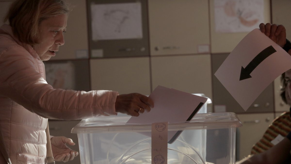 A woman holds her ballot at a polling station during the general elections, Sofia, Bulgaria, Oct. 27, 2024. (AP Photo)