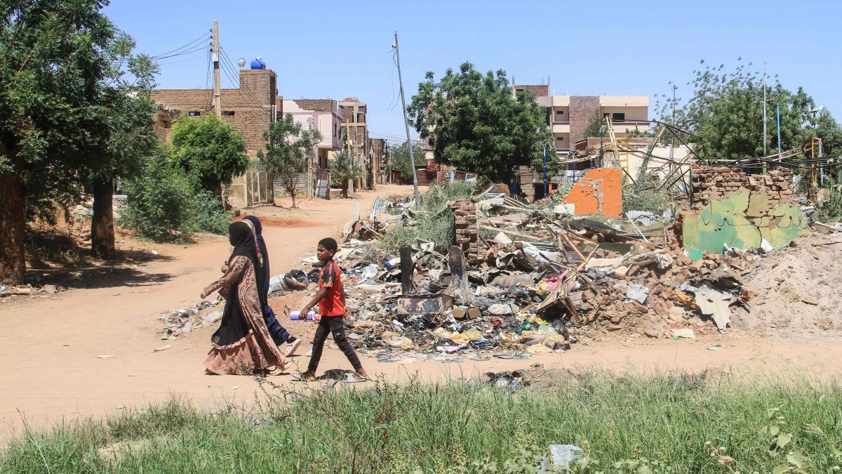 People walk past the rubble of a building on the third anniversary of the start of the war between the army and its paramilitary foes, in the capital Khartoum, Sudan, April 15, 2026. (AFP Photo)