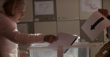 A woman holds her ballot at a polling station during the general elections, Sofia, Bulgaria, Oct. 27, 2024. (AP Photo)