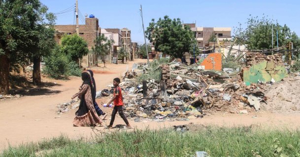 People walk past the rubble of a building on the third anniversary of the start of the war between the army and its paramilitary foes, in the capital Khartoum, Sudan, April 15, 2026. (AFP Photo)