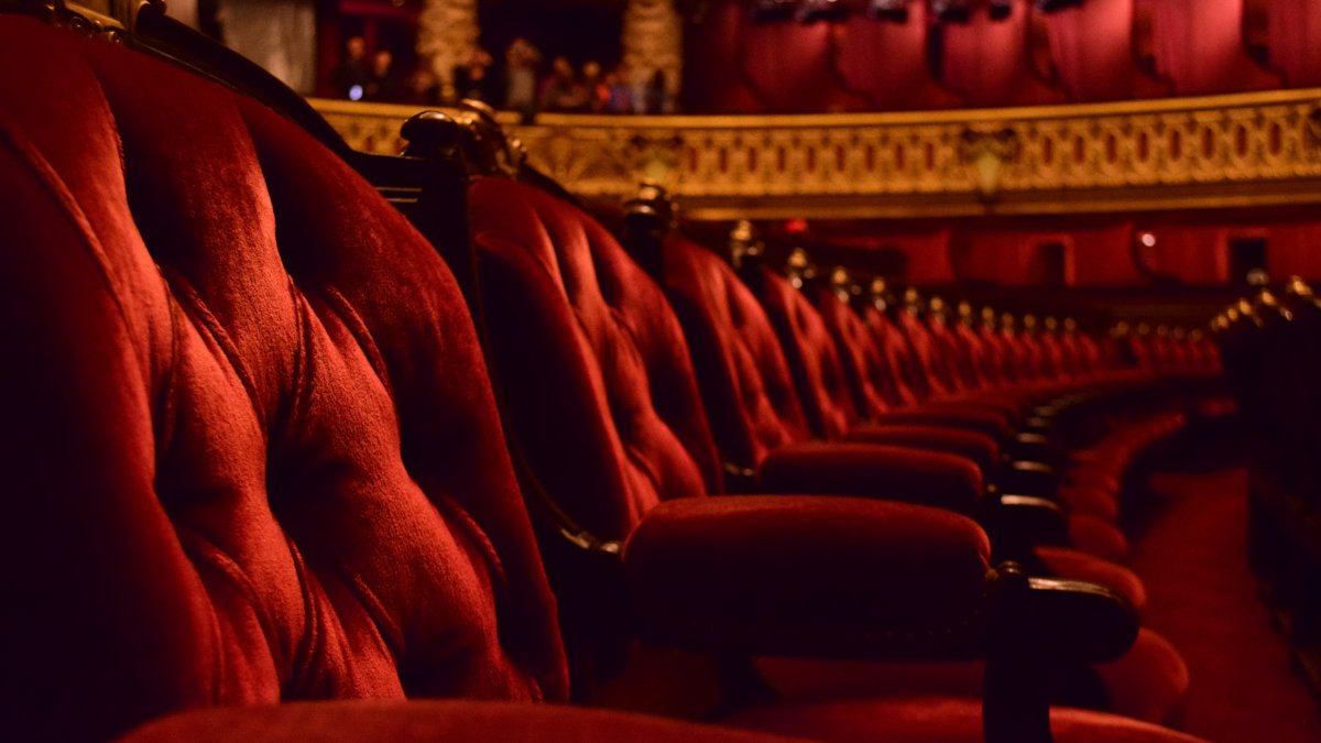 Rows of plush red velvet opera chairs with ornate gold trim. (Getty Images Photo)