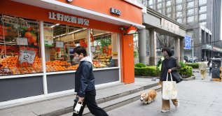 People walk in front of a fruit shop, Beijing, China, April 14, 2026. (EPA Photo)