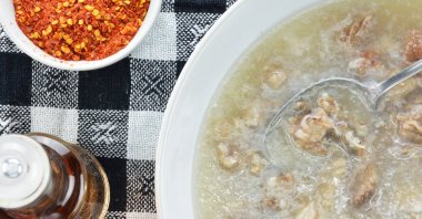 Patsa with a bottle of vinegar, chopped garlic, and a bowl of chili flakes. (Shutterstock Photo)