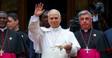Pope Leo XIV waves as he holds a white pigeon at Saint Joseph’s Cathedral in Bamenda, Cameroon, April 16, 2026. (Reuters Photo)
