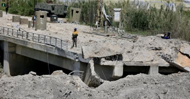 A man stands on a damaged part of the Qasmiyeh Bridge that was targeted by an Israeli airstrike near Tyre, southern Lebanon, April 16, 2026. (EPA Photo)