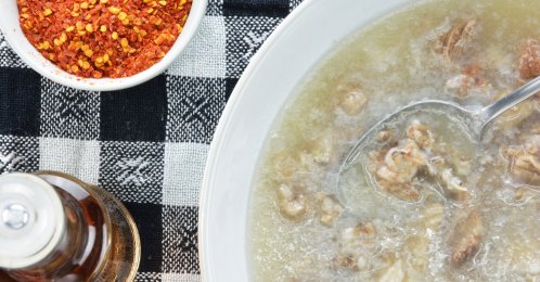 Patsa with a bottle of vinegar, chopped garlic, and a bowl of chili flakes. (Shutterstock Photo)