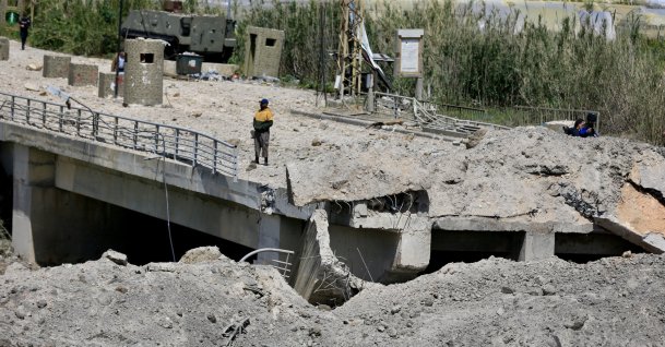 A man stands on a damaged part of the Qasmiyeh Bridge that was targeted by an Israeli airstrike near Tyre, southern Lebanon, April 16, 2026. (EPA Photo)