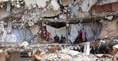 Displaced Palestinians sit outside a makeshift shelter amid the rubble of destroyed buildings at the Jabalia refugee camp in the northern Gaza Strip on April 13, 2026. (AFP Photo)