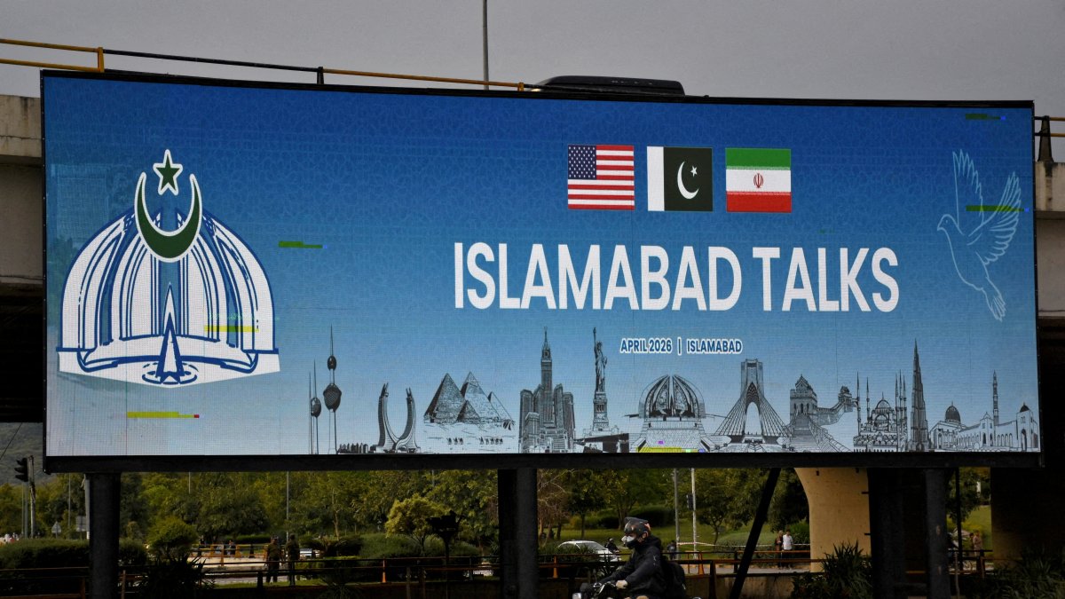 A man rides his motorbike past a billboard installed alongside a road as Pakistan prepares to host the U.S. and Iran for peace talks, in Islamabad, Pakistan, April 10, 2026. (Reuters Photo)