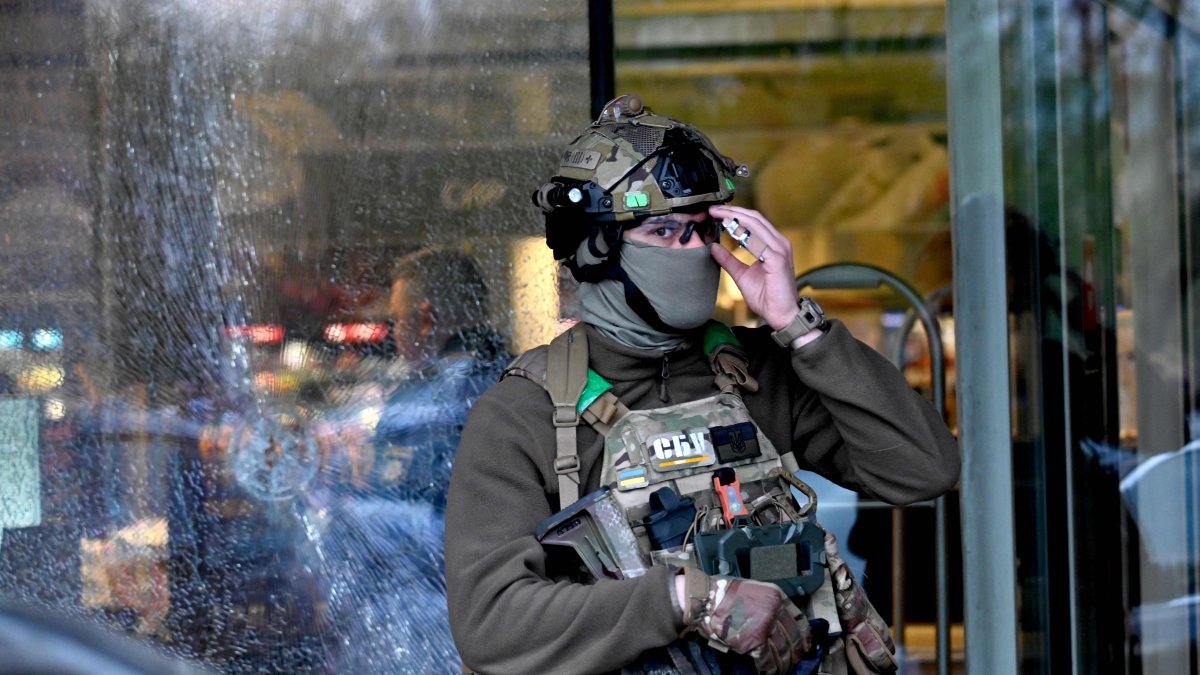 A special team policeman stands in front of a bullet hole in the window of a supermarket after a shooting in Kyiv, Ukraine, April 18, 2026. (AFP Photo)