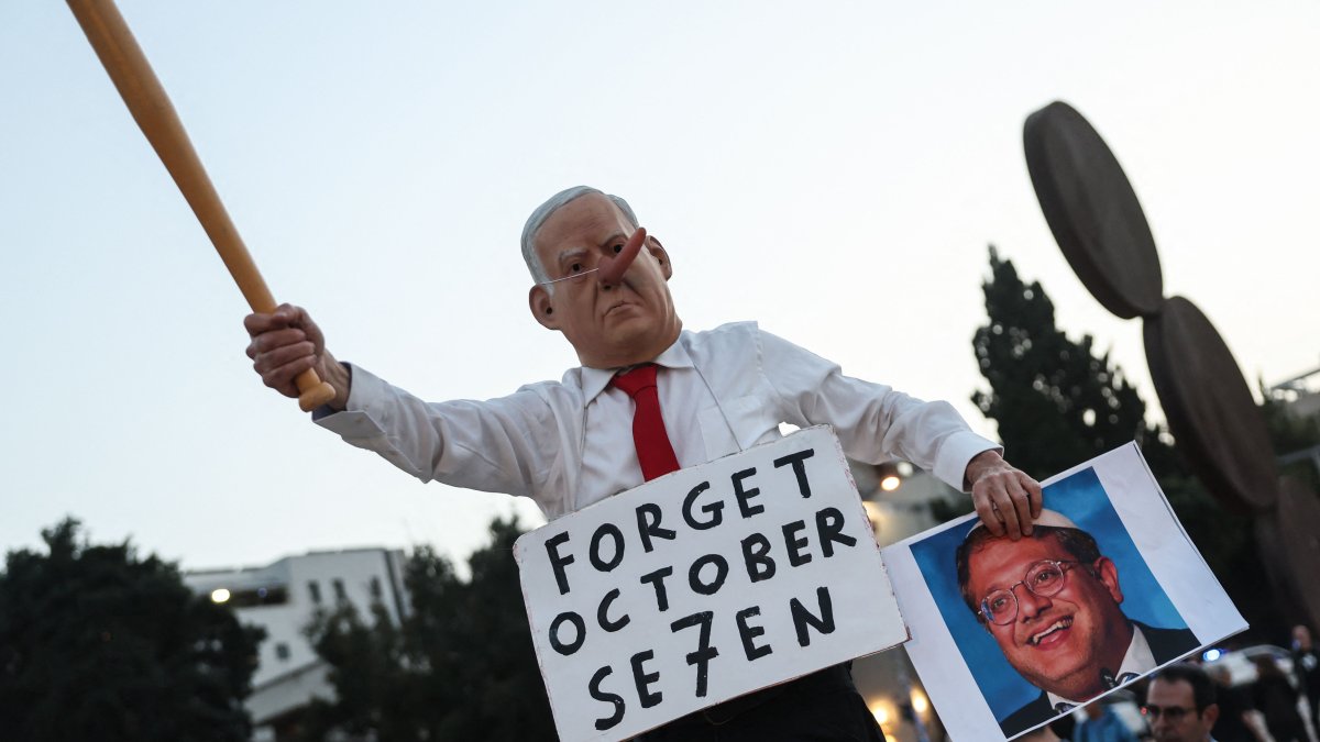 A protester dressed as the Israeli prime minister holds a portrait of far-right National Security Minister Itamar Ben Gvir during a demonstration in Tel Aviv, Israel, April 18, 2026. (AFP Photo)