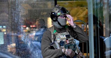 A special team policeman stands in front of a bullet hole in the window of a supermarket after a shooting in Kyiv, Ukraine, April 18, 2026. (AFP Photo)