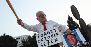 A protester dressed as the Israeli prime minister holds a portrait of far-right National Security Minister Itamar Ben Gvir during a demonstration in Tel Aviv, Israel, April 18, 2026. (AFP Photo)