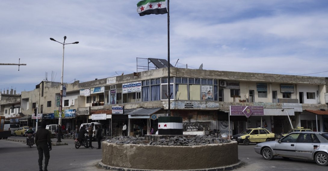 Cars drive past a roundabout hoisting the Syrian flag in Salam City, Quneitra, Syria, Jan. 5, 2025. (AP Photo)