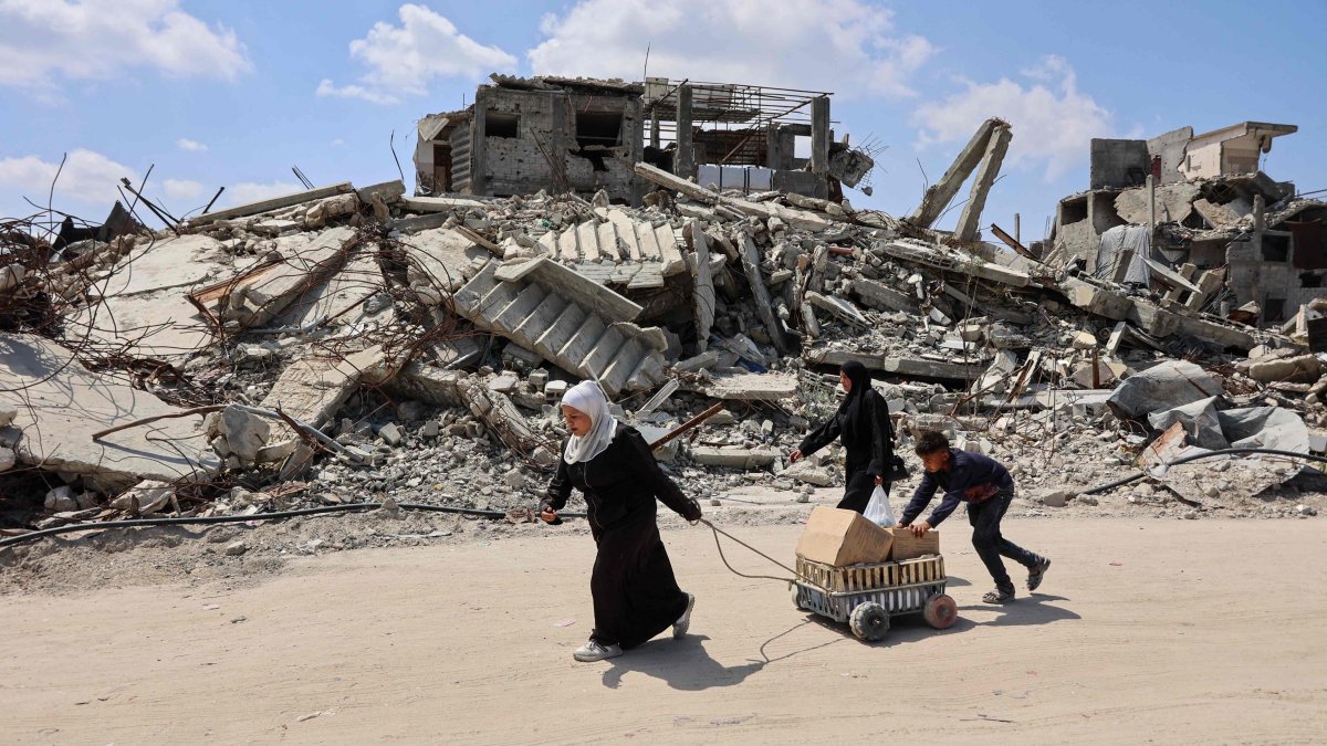 Displaced Palestinians carry boxes in a cart past the rubble of destroyed buildings at the Jabalia refugee camp, northern Gaza Strip, April 13, 2026. (AFP Photo)