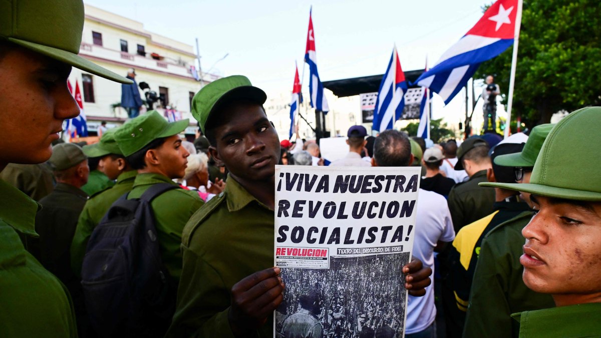 A member of the Ministry of the Interior holds a poster reading "Long live our socialist revolution" during celebrations marking the victory on the 65th anniversary of the Bay of Pigs invasion and the declaration of the socialist character of the Cuban Revolution in Havana, Cuba, April 16, 2026. (AFP Photo)